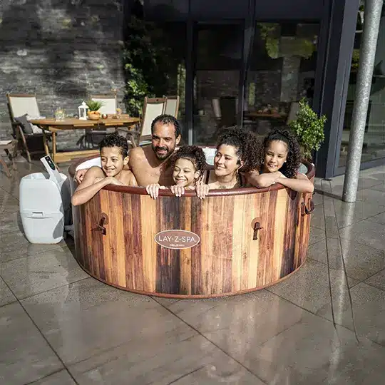 Hot tub at dusk in a Kent garden, steam rising, warm interior glow